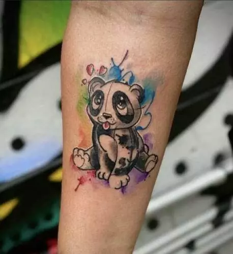 A tattoo of a cute, cartoon-style panda with a rainbow watercolor background on a person's forearm.