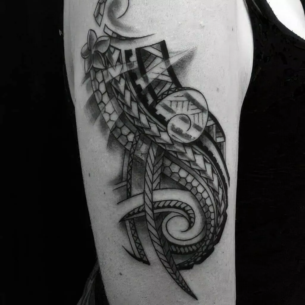 Close-up of an arm tattoo featuring a detailed, abstract design with intricate patterns, including geometric shapes, lines, and swirls. The tattoo is entirely in black ink.