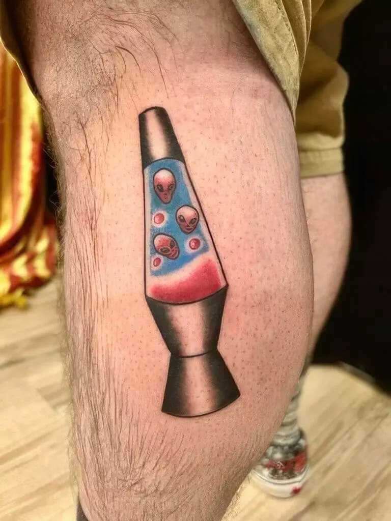 A leg with a tattoo of a lava lamp containing floating alien heads.