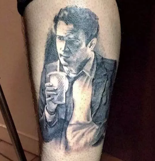 Realistic tattoo of a person in a suit drinking from a cup on the upper leg.