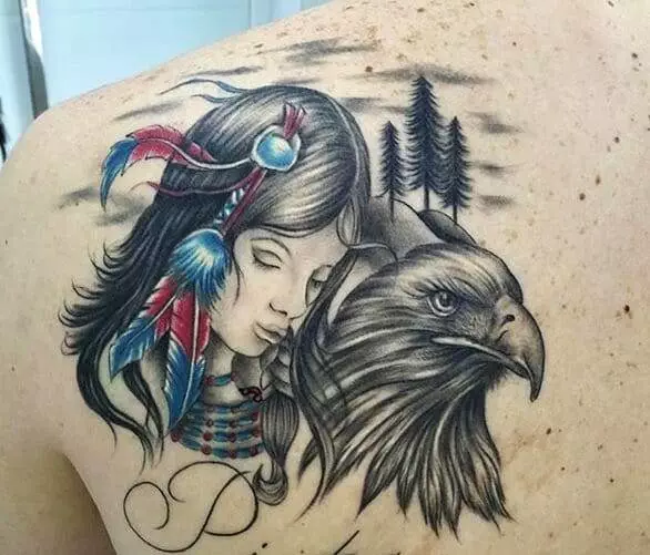 A tattoo depicting a woman with feathers in her hair beside an eagle, set against a backdrop of three trees, is on a person's upper back.