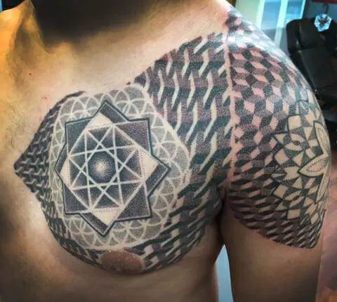 Chest and shoulder tattoo consisting of geometric patterns, including a central star shape and intricate designs extending over the shoulder and upper arm.